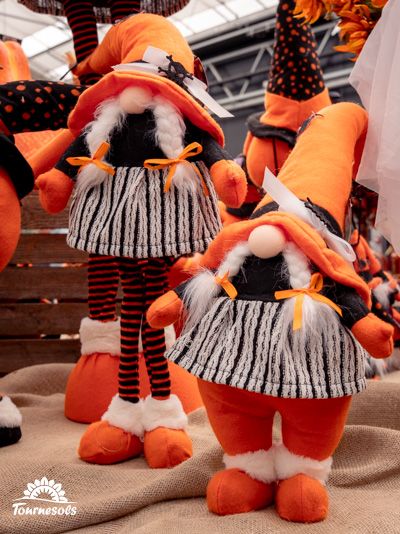 Deux personnages en tissu aux couleurs d'automne, avec chapeaux orange et détails noirs et blancs.